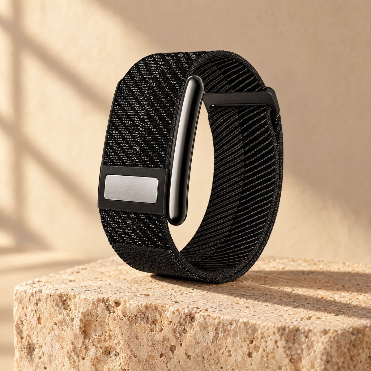Das VYTA Band mit schwarzem, elastischem Webband, schwarzer Sensorkapsel und Metallplakette am Schieber